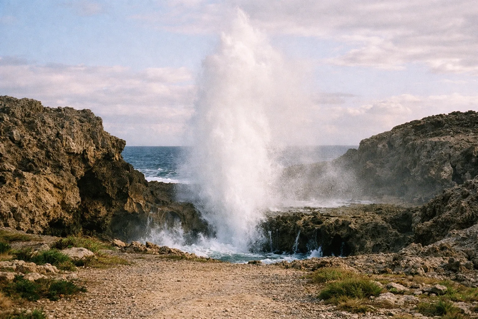 Pozo de Jacinto blowhole spraying water from a limestone cliff along the Isabela coast