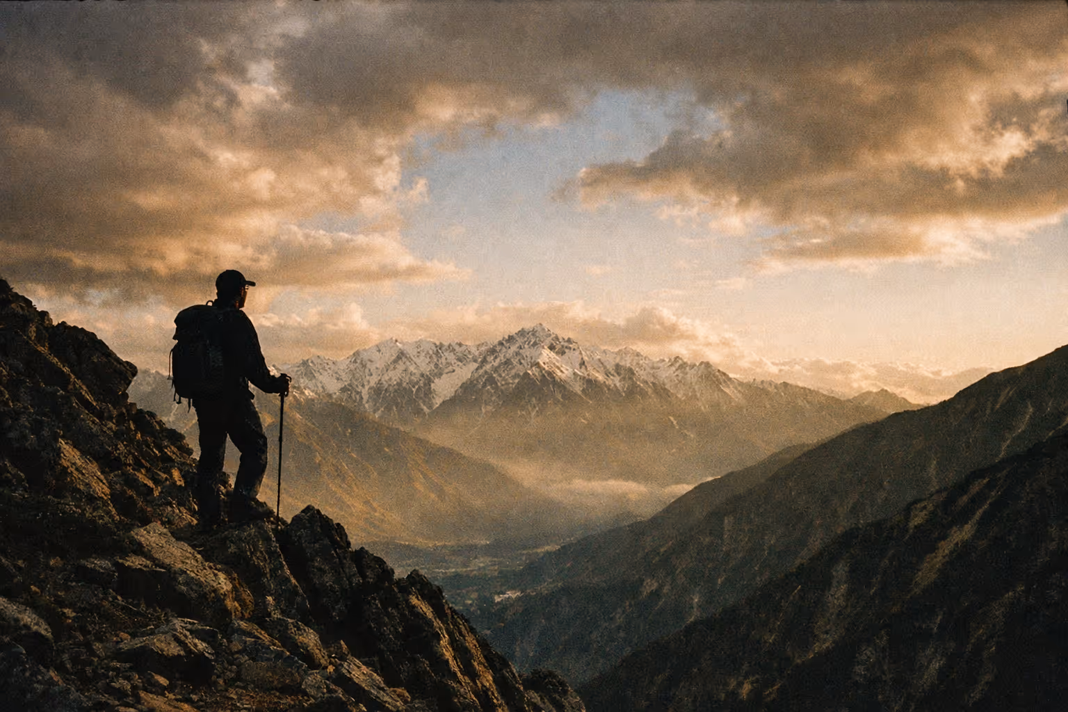 Wide, cinematic view of a rugged Japanese Alps landscape at golden hour with a lone hiker silhouette on a ridge