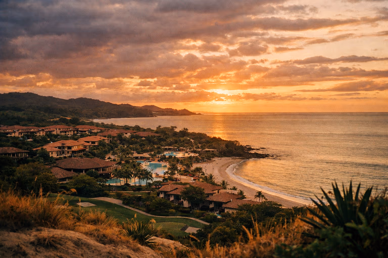 Sunset over the Westin Reserva Conchal coastline, with the resort nestled among tropical hills