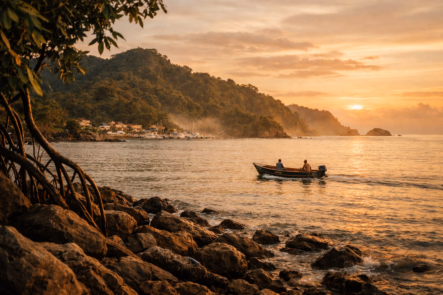 Quepos coastline at golden hour with jungle hills and a small boat at sea