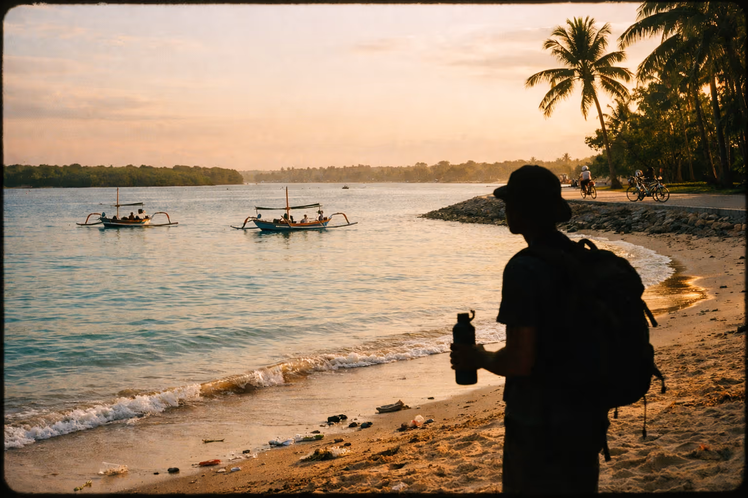 Editorial scene of Sanur Beach at sunrise, calm east-coast waters with resort-fronted shoreline and distant mangroves, hinting at plastic pollution along the high-tide line.