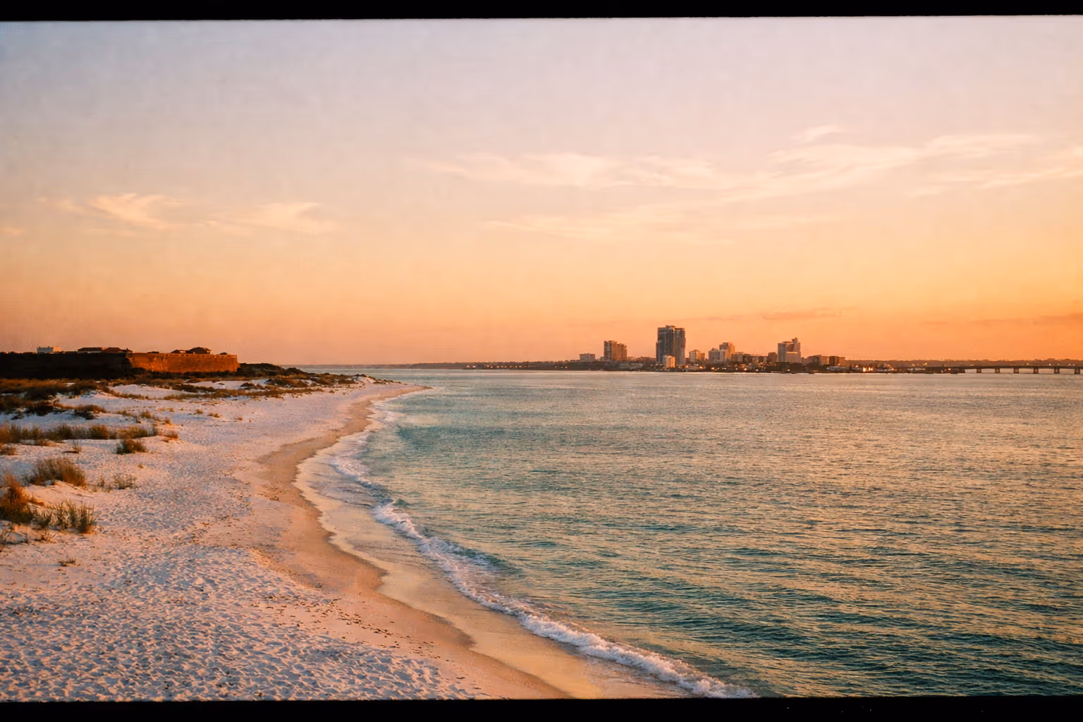 Pensacola coastline panorama at golden hour showing Fort Pickens, Santa Rosa Island, and downtown Pensacola
