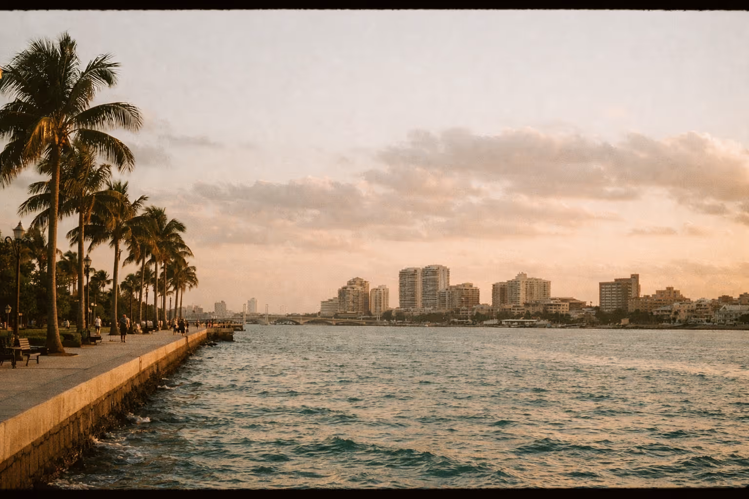 Golden-hour panorama of West Palm Beach coastline with palm-lined promenade