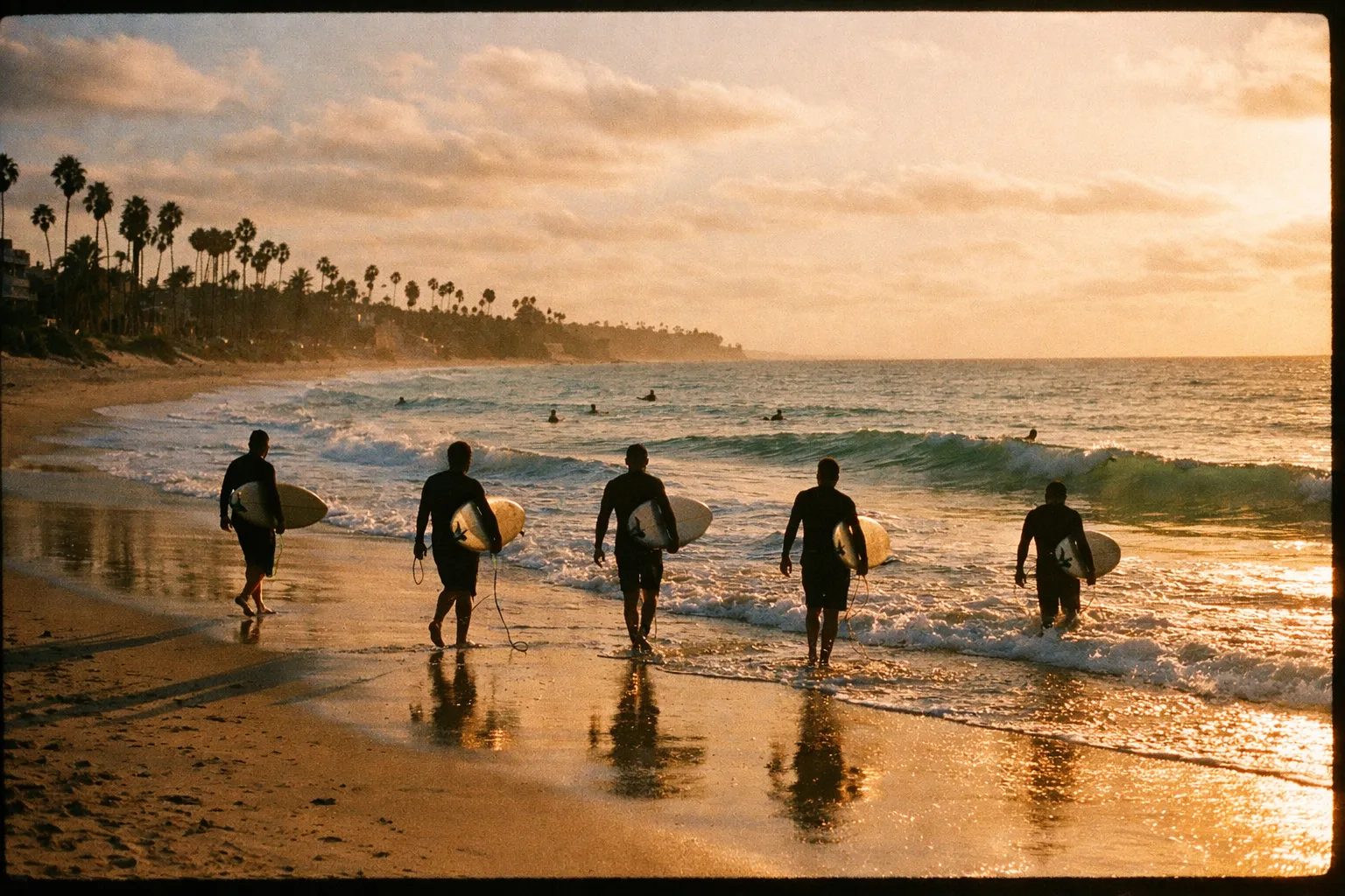 Surfers as silhouettes walking into turquoise waves along a quiet Costa Rican beach at sunset