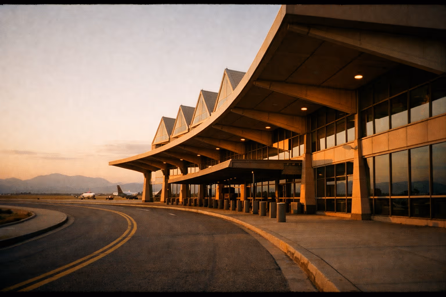COS terminal exterior at golden hour with curbside loop, travel mood